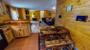 A cozy wooden cabin interior with a kitchen, dining area, and living room. - Secluded Black Bear Lodge w/ Private Pool & Hot Tub near Hocking Hills Ohio (Nelsonville)