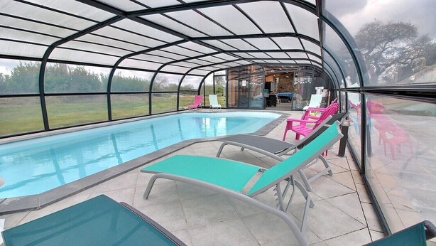 A covered swimming pool with lounge chairs and a view of the outdoors. - L'Hortensia - PLEUDANIEL (PLEUDANIEL)
