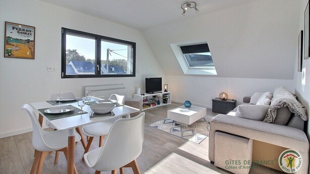 Eine moderne Wohnung mit Essbereich, Wohnzimmer und einem großen Fenster mit Blick.