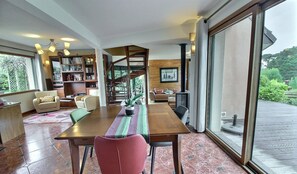 Un vaste espace dédié à la salle à manger, avec une table en bois, des chaises rouges et un chemin de table à rayures.