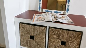 A white cabinet with a red top, a mirror with a fish design, and two woven baskets. - Kerborn - PLOUGUIEL - Gîte (PLOUGUIEL)