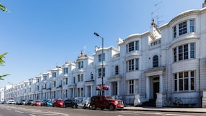 A row of white terraced houses with a clear blue sky. - Elegant, Airy 2 Bedroom Flat in Paddington (London)