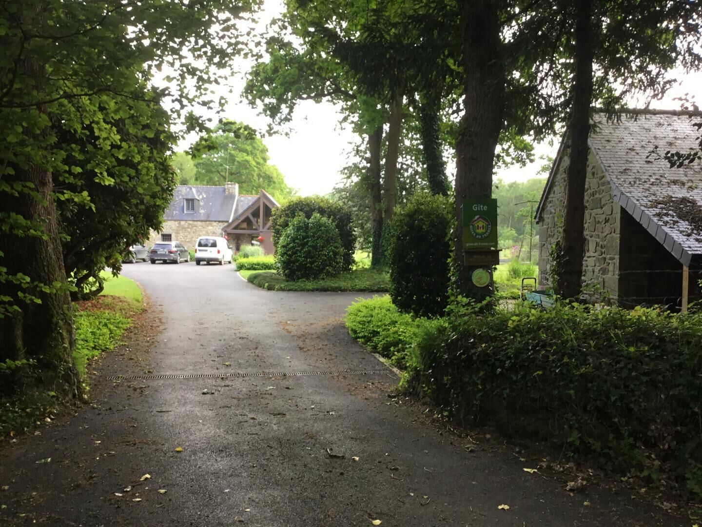 Un camino rural que lleva a una edificación de piedra con un cartel que indica 'Gîte de France'.