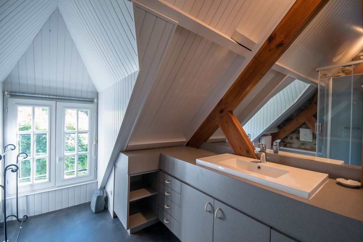 Ein modernes Badezimmer mit großem Fenster, integriertem Waschbecken und Spiegel.