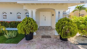 A building with a white facade, a number '520' on the right, and a front door with a small balcony above it. - Sleeps 16 @ Palm Beach - 6BR Villa w/ Private Pool (Palm Beach)