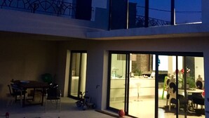 A modern two-story house with large windows, a dining area with a table and chairs, and a visible kitchen area. - Luxury loft with pool and garden (Avignon)