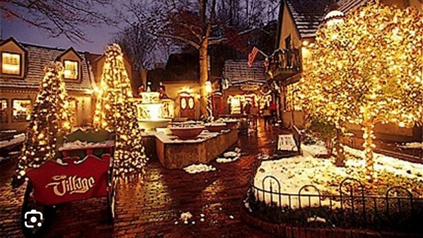 Escena de un pueblo con edificios iluminados y un cartel que dice 'Village'.