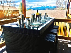 A dining table set outdoors with a mountain view.