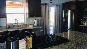 A kitchen with granite countertops, stainless steel appliances, and dark wooden cabinets. - The Aspen - in WPCO at 8488 ft elevation (Woodland Park)