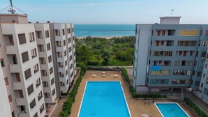A swimming pool surrounded by apartment buildings, with a view of the sea in the background. - [lido Adriano Free Parking]appartamento SUL Mare (Lido Adriano)
