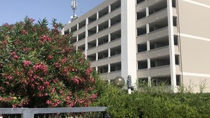 A multi-story parking garage with a modern design, featuring a series of balconies and a central column. - [lido Adriano Free Parking]appartamento SUL Mare (Lido Adriano)