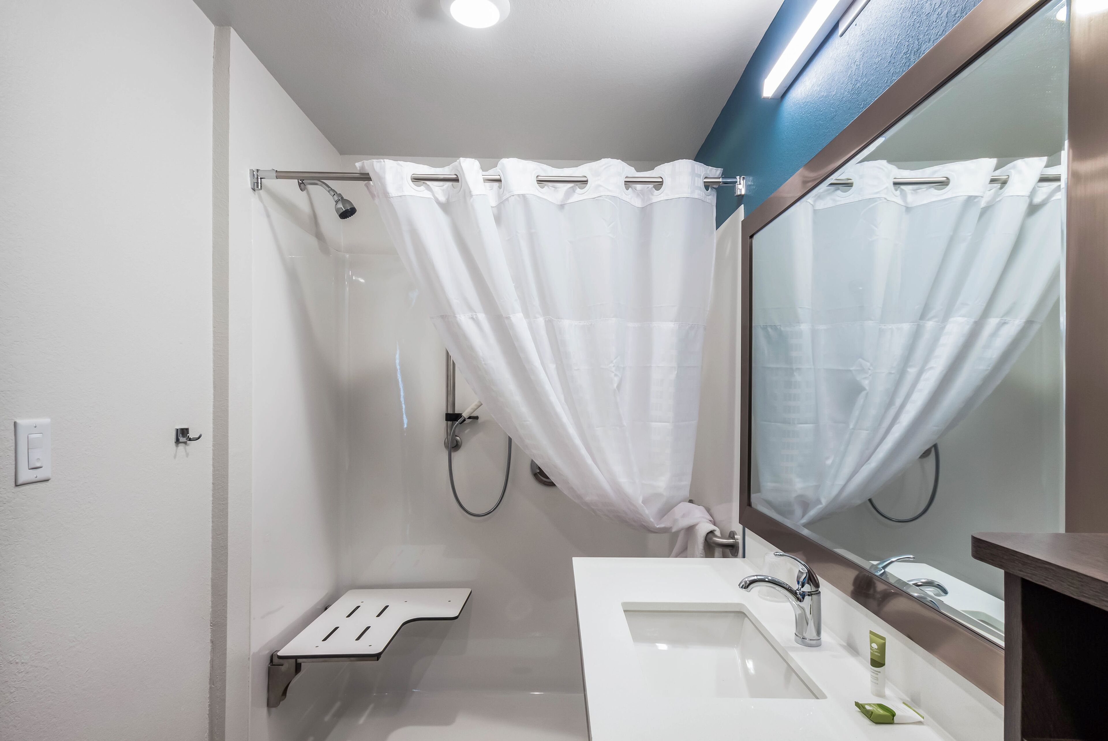Un baño moderno con ducha, lavabo y espejo.