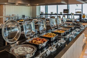 A buffet with various food options, including pasta, salads, and meats.