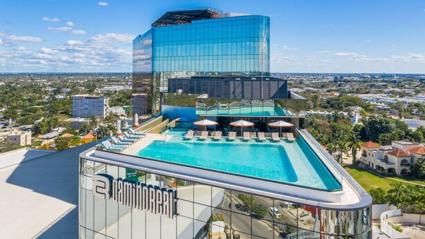 A modern hotel with a rooftop pool, clear views of the city, and a prominent glass facade. - Camino Real Mérida (Mérida)