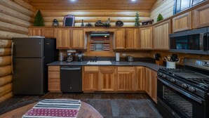 A log cabin kitchen with wooden cabinets, a refrigerator, a stove, and a microwave. - 2 Blue Feather in Beautiful Greer AZ (Greer)