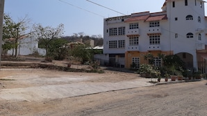 Ein mehrstöckiges Hotel mit weißer Fassade und rotem Dach, mit Balkonen und zahlreichen Fenstern.
