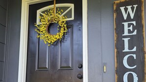 A dark wooden front door with a wreath and a 'WELCOME' sign. - The Flippin Fisherman  (Flippin)