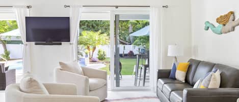 TV connectée, cheminée, livres, écrans d'ordinateur