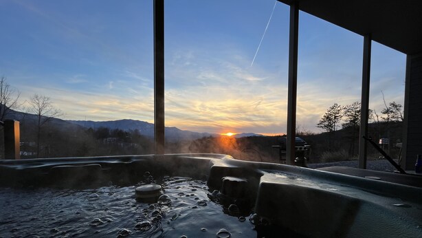Un bain à remous avec vue sur les montagnes et un coucher de soleil.
