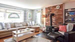 Una sala de estar acogedora con un sofá seccional, una mesa de centro y una chimenea.