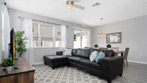 A modern living room with a sectional sofa, a wooden coffee table, and a patterned rug.