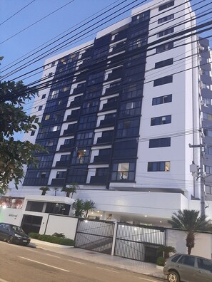 A multi-story building with a modern architectural design, featuring a combination of dark and light facade elements.
