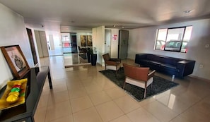 A spacious lobby with a reception desk, seating area, and a large window.