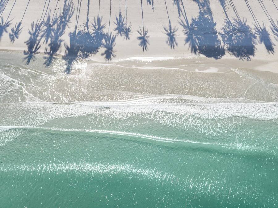 A beach with clear turquoise waters and white sand.