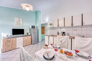 A modern kitchen with a dining area, a flat-screen TV, and a refrigerator. - Turquoise Apartment Sea View, Jasenice, Croatia (Jasenice)