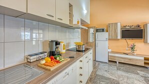 Una cocina moderna con gabinetes blancos, encimera de madera y microondas integrado.