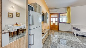 Un espacio habitable compacto con comedor, kitchenette y sofá.