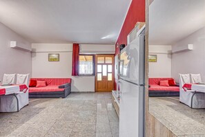 Une chambre avec deux lits, un réfrigérateur et une fenêtre avec des rideaux.