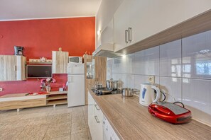 A modern kitchen with wooden cabinets, a built-in microwave, and a red appliance on the counter. - Cherry Apartment With Sea View, Jasenice, Croatia (Jasenice)