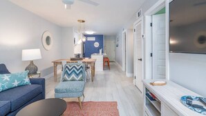 Un salon moderne avec un canapé, une table à manger et un téléviseur.