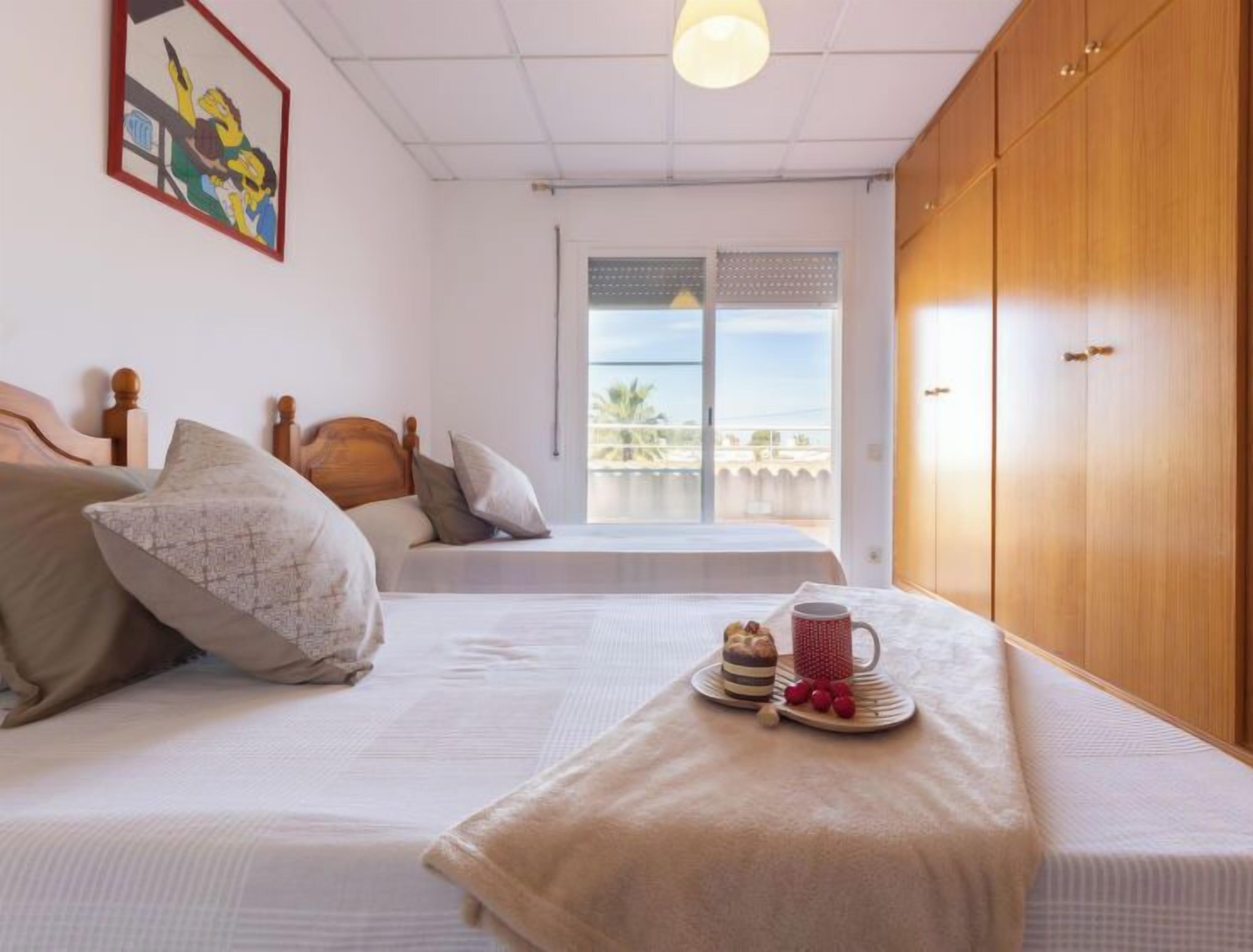 A bedroom with a bed, a window with a view, and a wardrobe.
