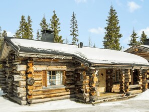A log cabin with a snow-covered roof, a chimney, and a window. - Luostonseita 1 by Interhome (Sodankylä)