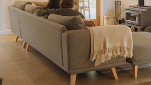 Een moderne woonkamer met een bank, een open haard en een groot raam.