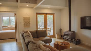A modern living room with a sectional sofa, a fireplace, and a dining area with a table and chairs.