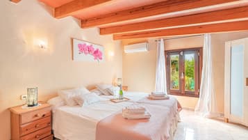 A bedroom with a wooden ceiling, a bed with white bedding, a nightstand with a lamp, and a window with curtains.