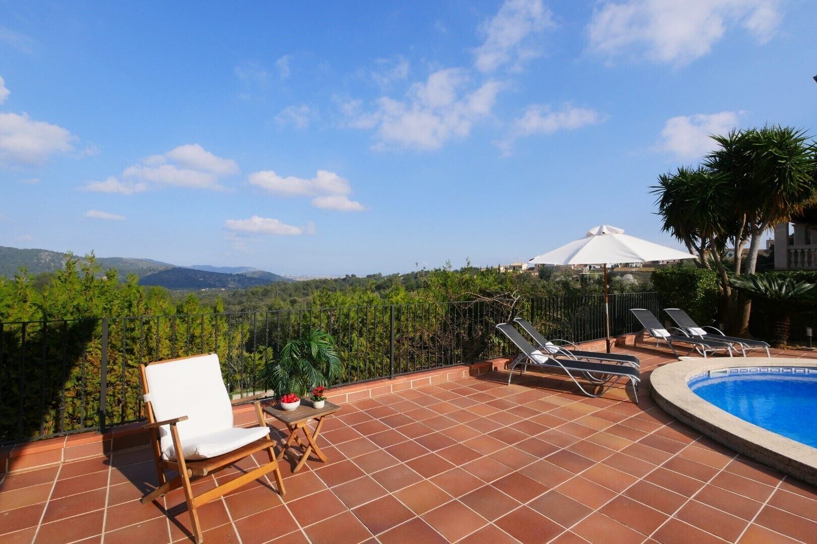 Une terrasse sur le toit avec une piscine, des chaises longues et une vue sur le paysage environnant.