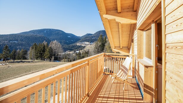 Ein Holzbalkon mit Blick auf Berge.
