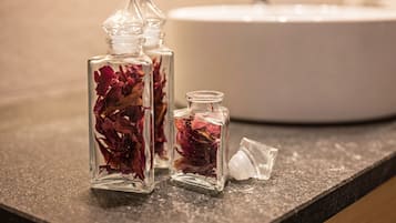 Trois bouteilles en verre contenant des fleurs séchées, posées sur un comptoir.