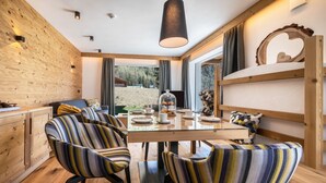 Un comedor moderno con una mesa de madera, sillas a rayas y vistas al exterior.