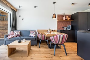 Un espacio moderno con un sofá, una mesa de comedor y sillas a rayas.