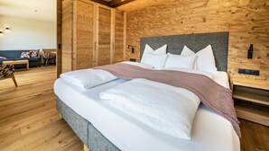 A modern bedroom with a large bed, wooden walls, and a wooden floor. - Apartment "Mulin Loise" next to the Skiing Area with Mountain View, Sauna & Garden (Vals)
