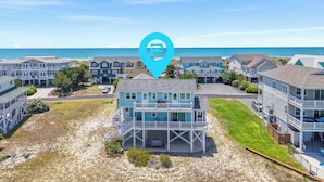 A beachfront property with a prominent location marker, multiple-story buildings, and a view of the ocean. - "It Was A Good Day" - 2nd Row Home, 4 Bedrooms / 4.5 Bathrooms (Holden Beach)