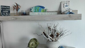 Een plank met decoratieve vissen, een bord en een kleine plant.