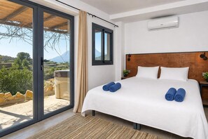 A hotel room with a bed, a window, and a view of the countryside.