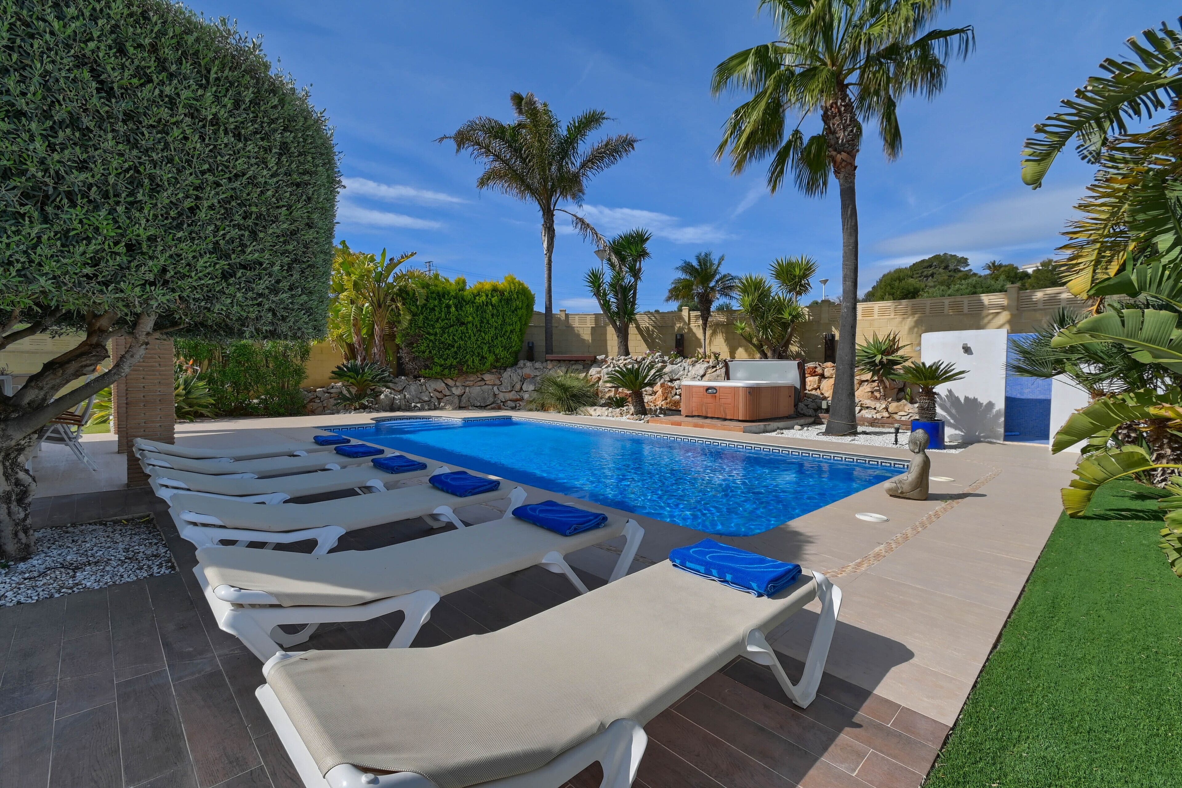 A pool area with lounge chairs and a statue.
