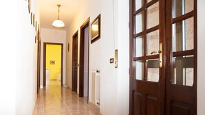 A hallway with a tiled floor, wooden doors, and a radiator. - Holiday home "Da Maria Maddalena" n ° 1  (Sardegna)